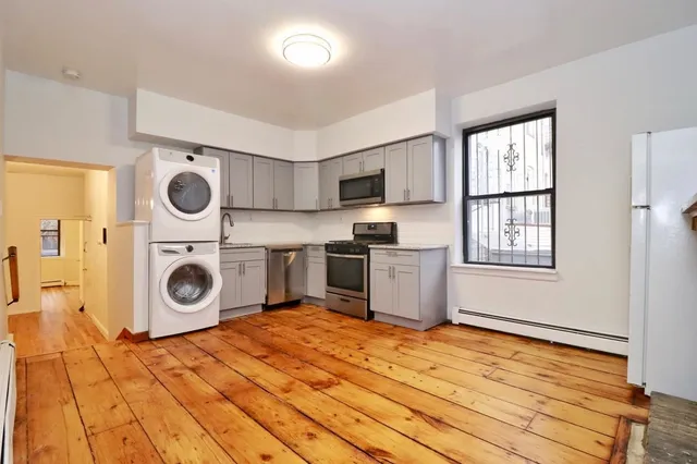 a view of a kitchen with wooden floor and washing machine
