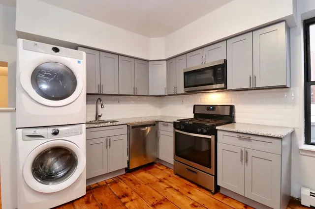 a kitchen with cabinets stainless steel appliances and a sink