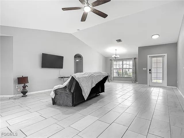 a spacious bedroom with a bed and a chandelier