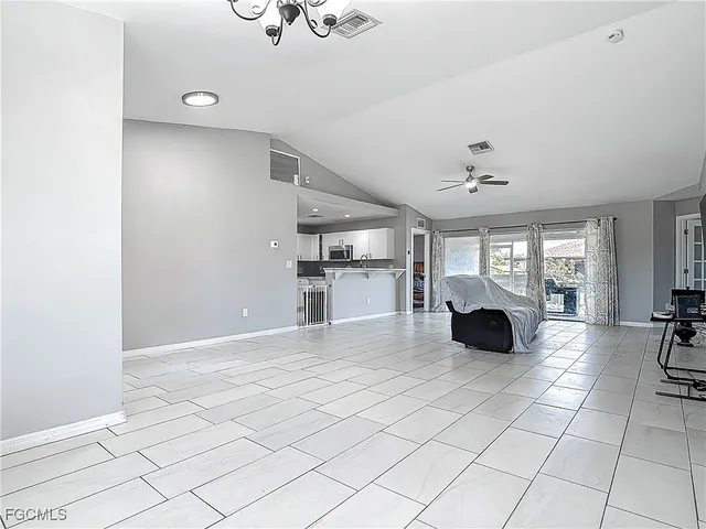 a spacious bedroom with a bed and ceiling fan