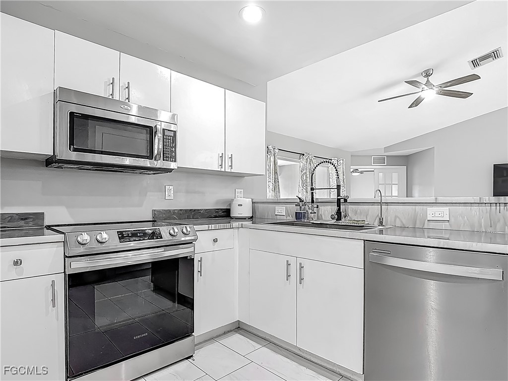 2732 Northwest 3rd Terrace Cape Coral, FL 33993 - Photo 7 of 9 a kitchen with cabinets stainless steel appliances and a sink