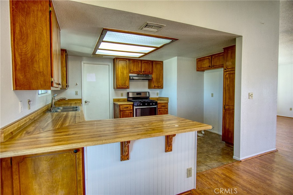 4818 Round Up Road Twentynine Palms, CA 92277 - Photo 11 of 25 a kitchen with stainless steel appliances granite countertop a sink and a refrigerator