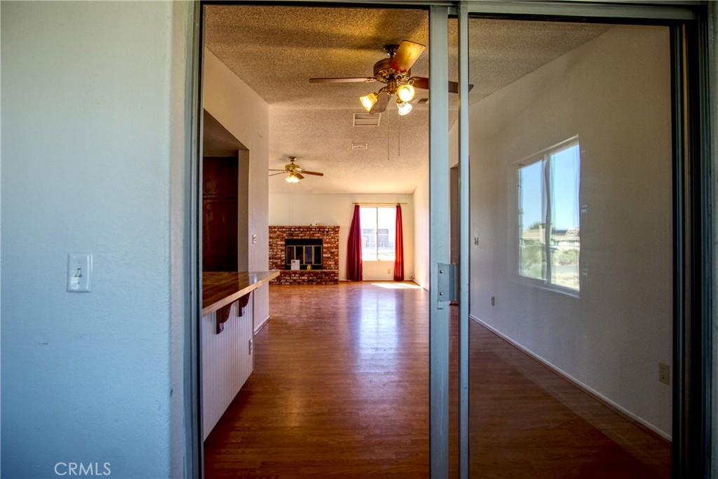 4818 Round Up Road Twentynine Palms, CA 92277 - Photo 12 of 25 a view of a hallway with wooden floor and a living room