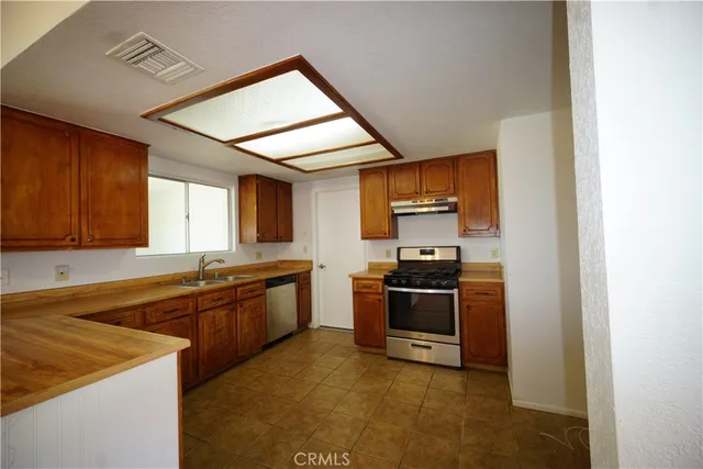 a kitchen with stainless steel appliances granite countertop a stove a sink and a refrigerator