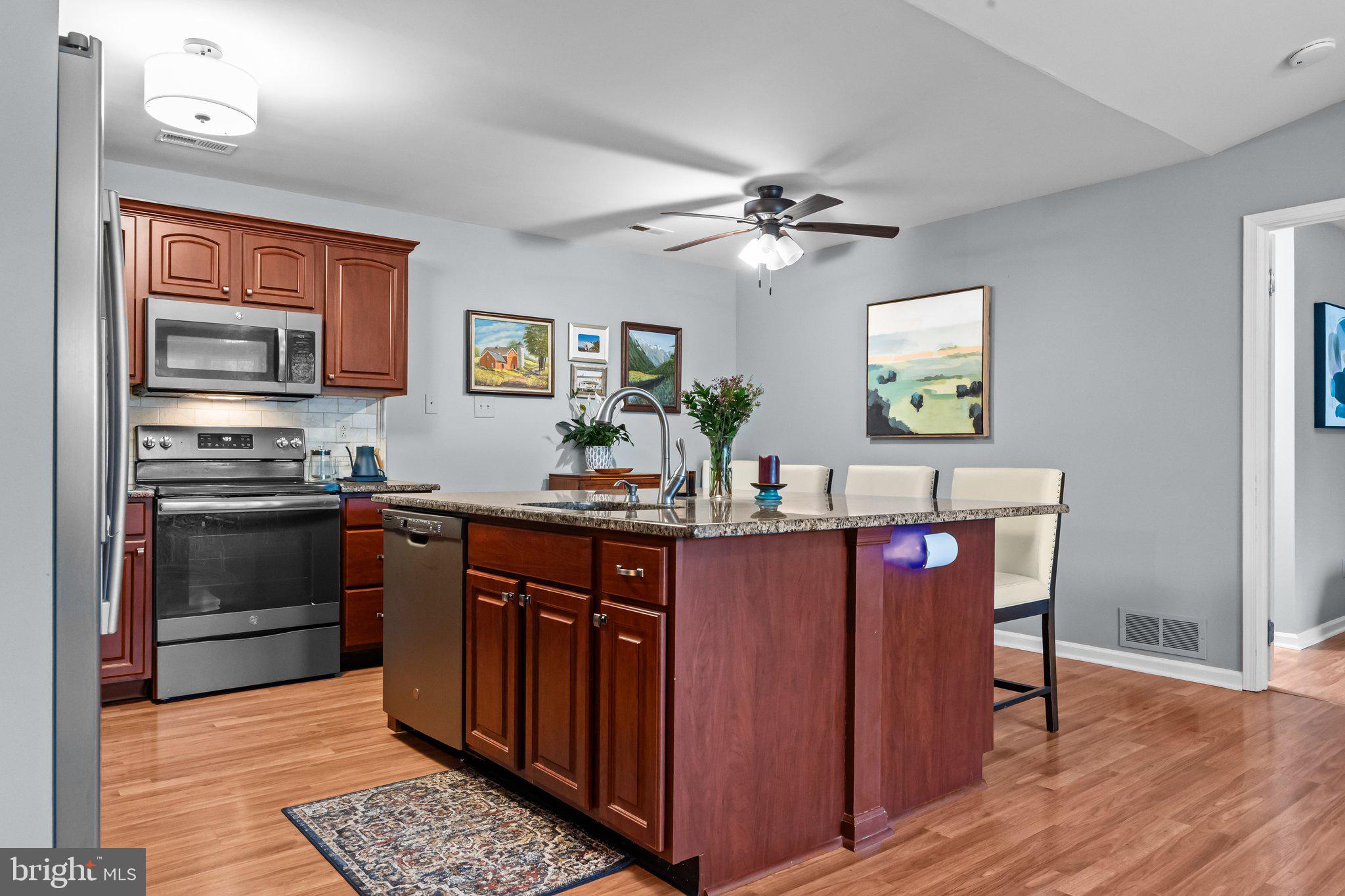 12306 Cornerstone Drive Yardley, PA 19067 - Photo 5 of 25 a kitchen with stainless steel appliances granite countertop a stove a sink dishwasher and a refrigerator with wooden floor