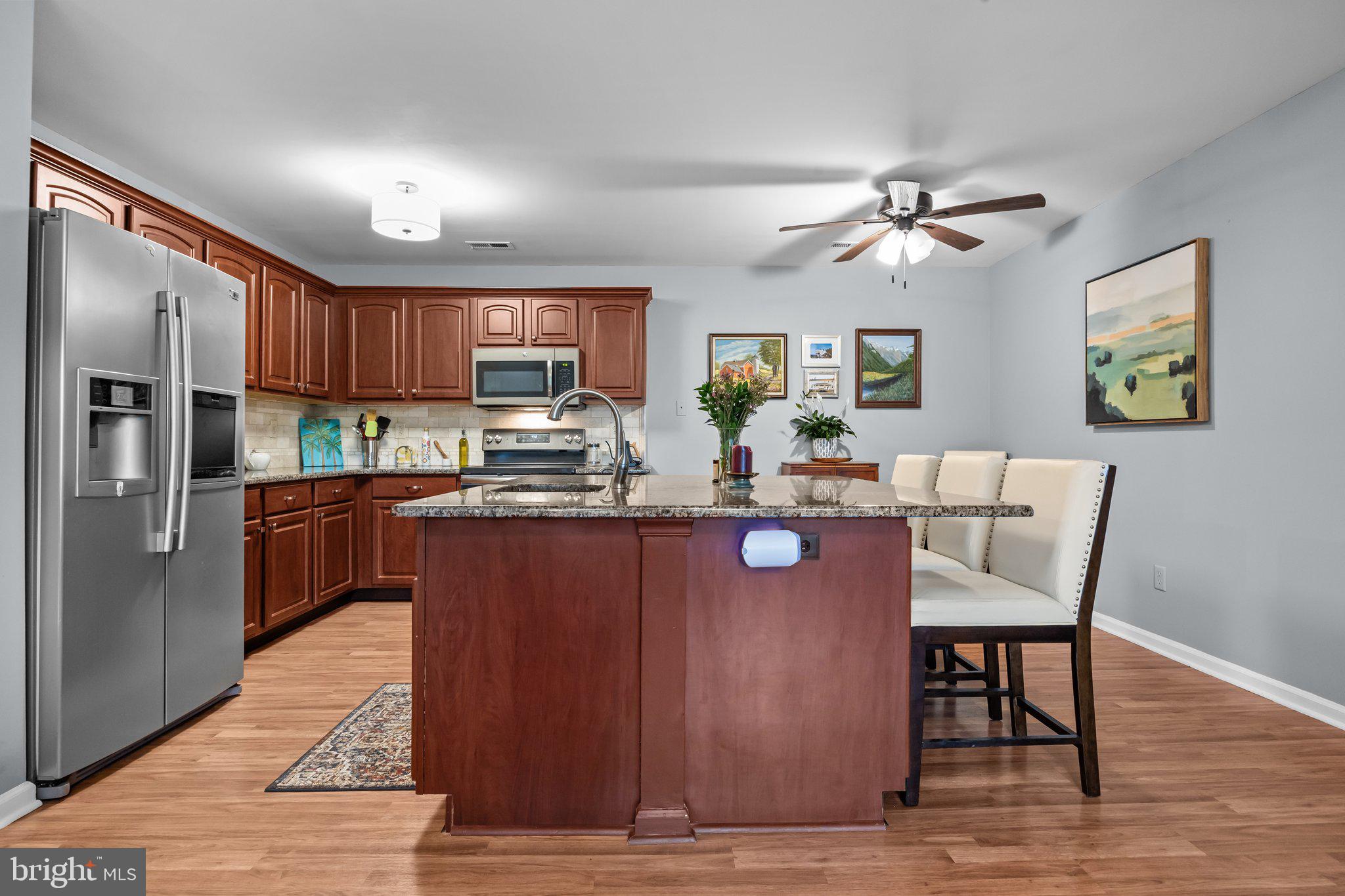 12306 Cornerstone Drive Yardley, PA 19067 - Photo 8 of 25 a kitchen with stainless steel appliances granite countertop a refrigerator a sink dishwasher a stove with wooden cabinets and floor