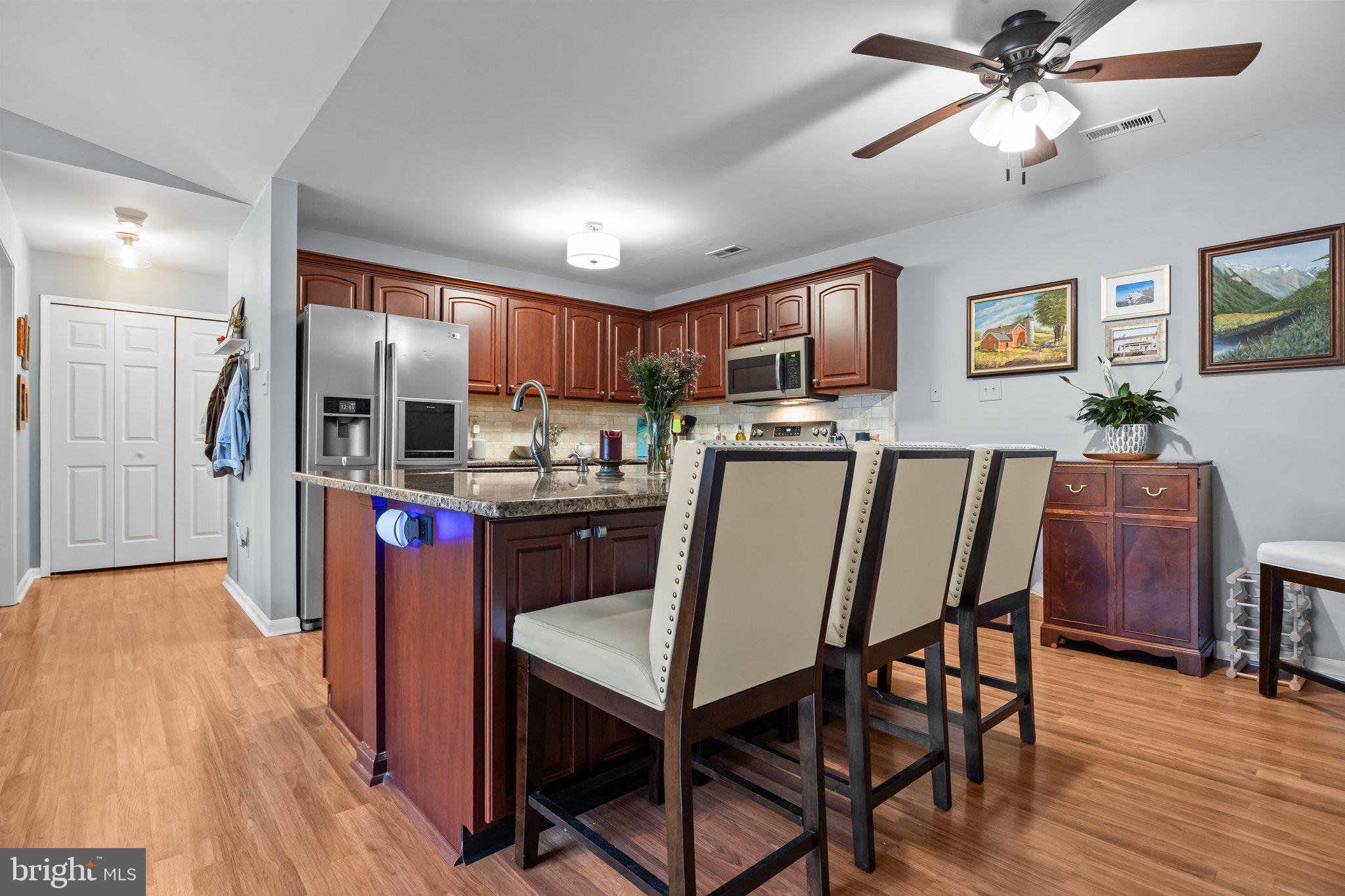 12306 Cornerstone Drive Yardley, PA 19067 - Photo 9 of 25 a kitchen with stainless steel appliances granite countertop a refrigerator a stove top oven a sink dishwasher and white cabinets with wooden floor