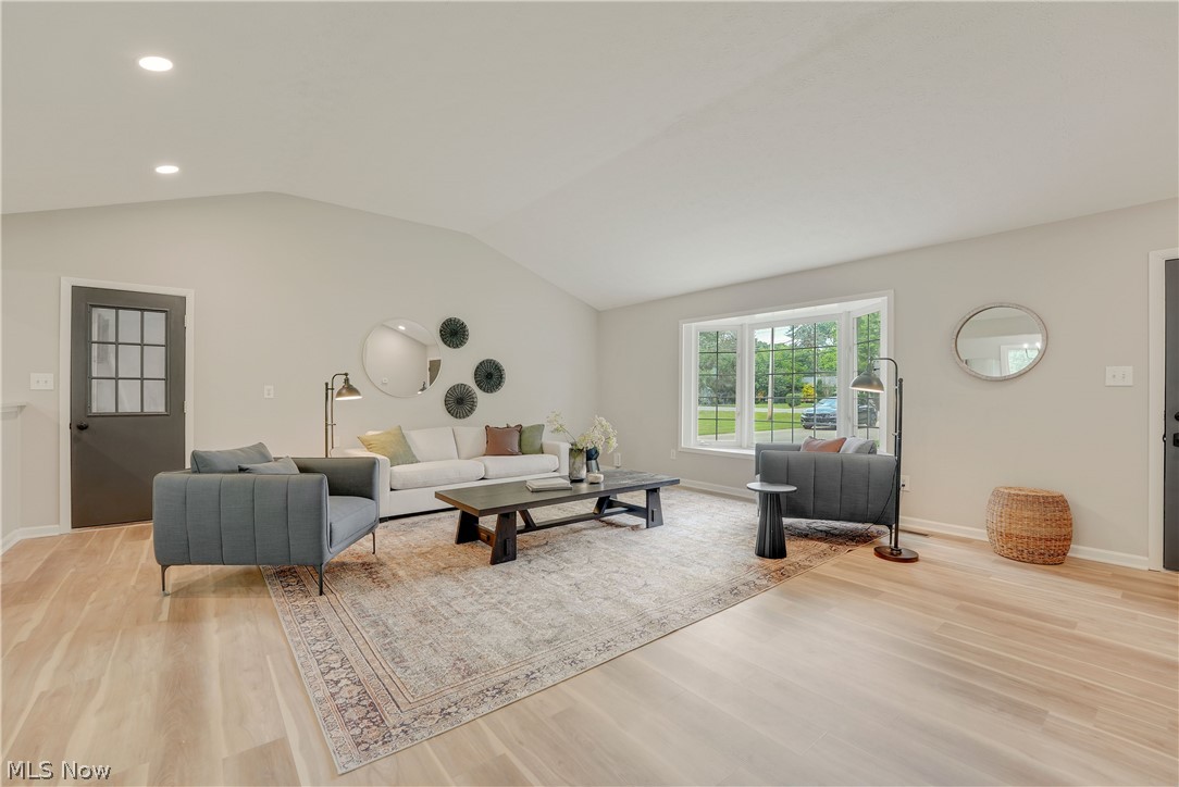 646 Ledge Road Macedonia, OH 44056 - Photo 4 of 28 Spacious living area featuring a vaulted ceiling with recessed lighting, light wood-finish flooring, and a large multi-pane window