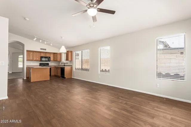 a view of a kitchen with a stove cabinets a ceiling fan and wooden floor