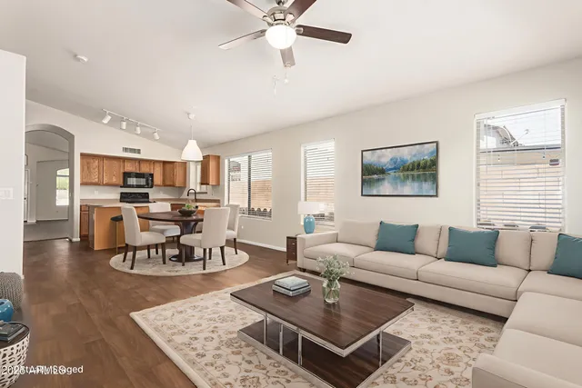 a living room with furniture kitchen view and a table