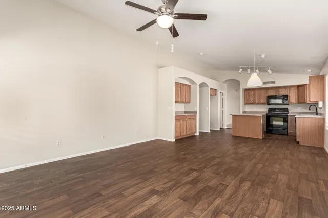 a view of a livingroom with wooden floor and a ceiling fan