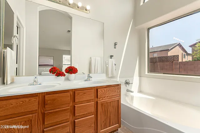 a bathroom with a sink vanity tub and a mirror