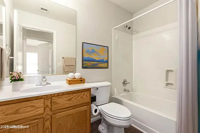 a bathroom with a granite countertop sink toilet and a bathtub