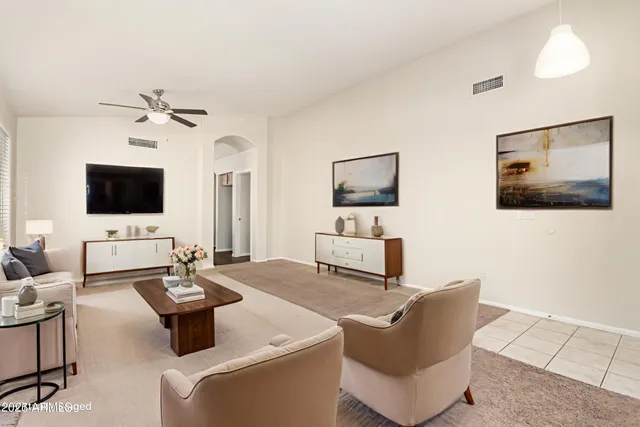 a living room with furniture a flat screen tv and white walls