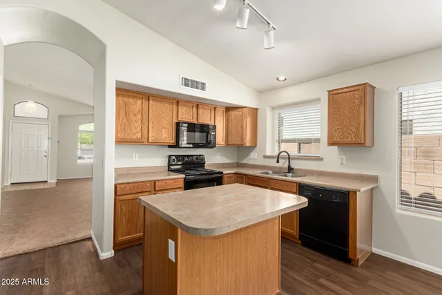 a kitchen with stainless steel appliances granite countertop a sink stove microwave and refrigerator