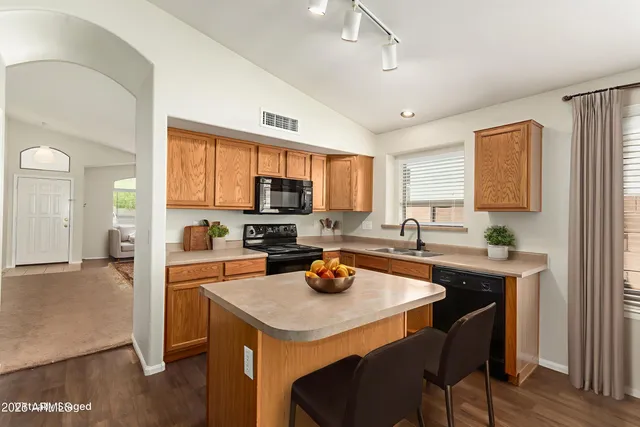 a kitchen with a stove a sink a dining table and chairs