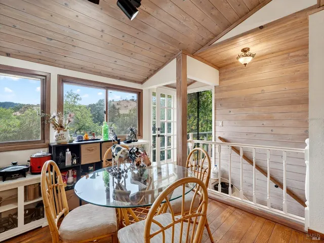 a dining room with furniture a chandelier and wooden floor