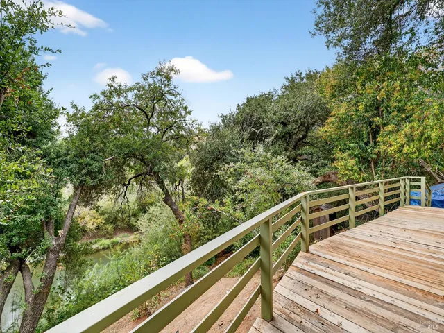 a view of an empty room and a chandelier fan