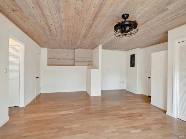 a view of empty room with wooden floor