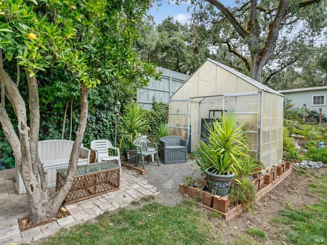 a view of a backyard with table and chairs under an umbrella