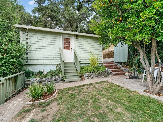 a view of a patio with table and chairs under an umbrella