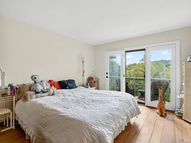 a bedroom with a bed and large windows