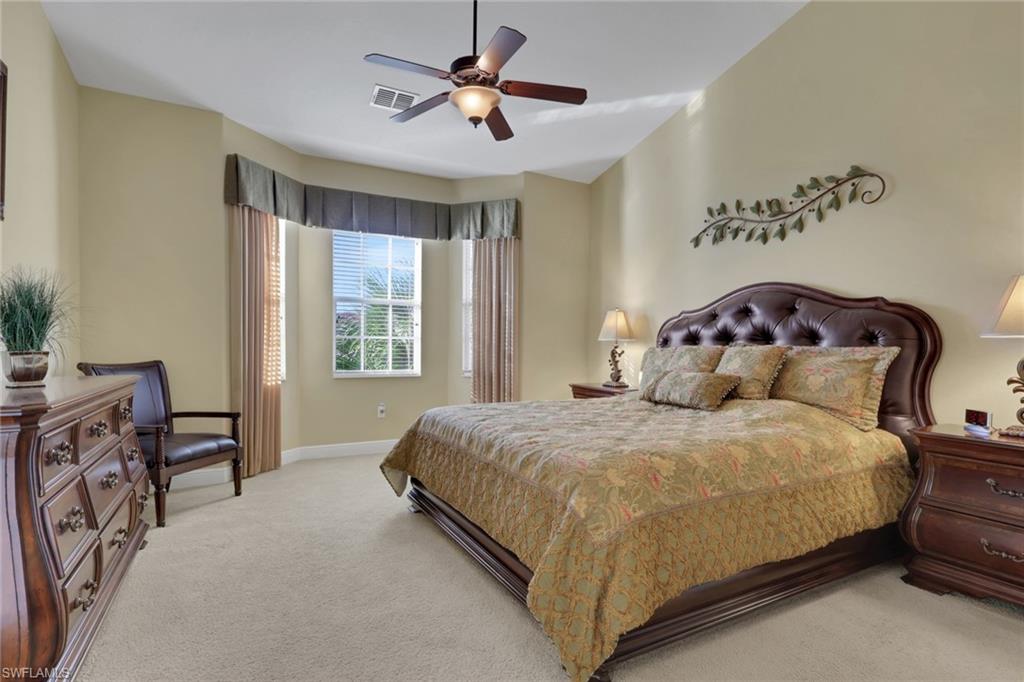 6397 Legacy Circle, Unit 2003 Naples, FL 34113 - Photo 22 of 26 a bedroom with a bed and a chandelier