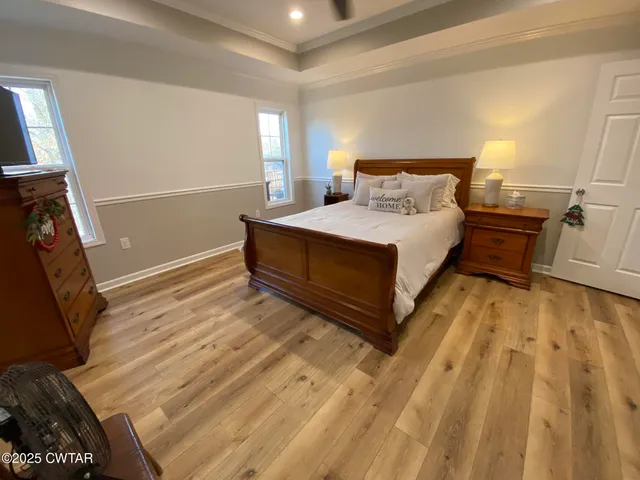 a bedroom with a bed and a flat tv screen on wall