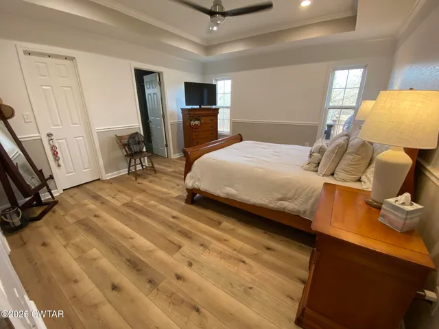 a bedroom with a bed a dresser and flat screen tv