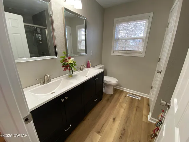 a bathroom with a sink vanity granite and toilet