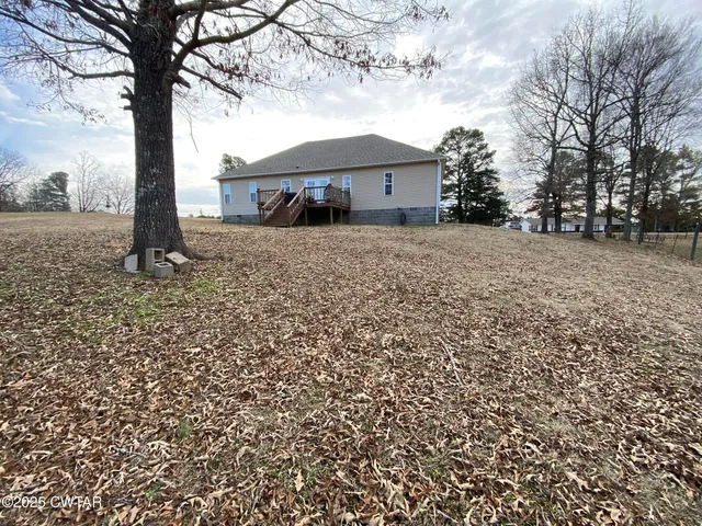 a front view of a house with a garden and trees