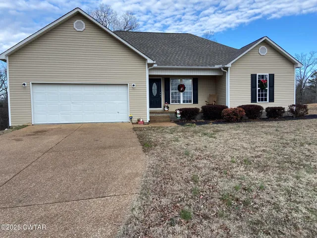 a front view of a house with yard and garage