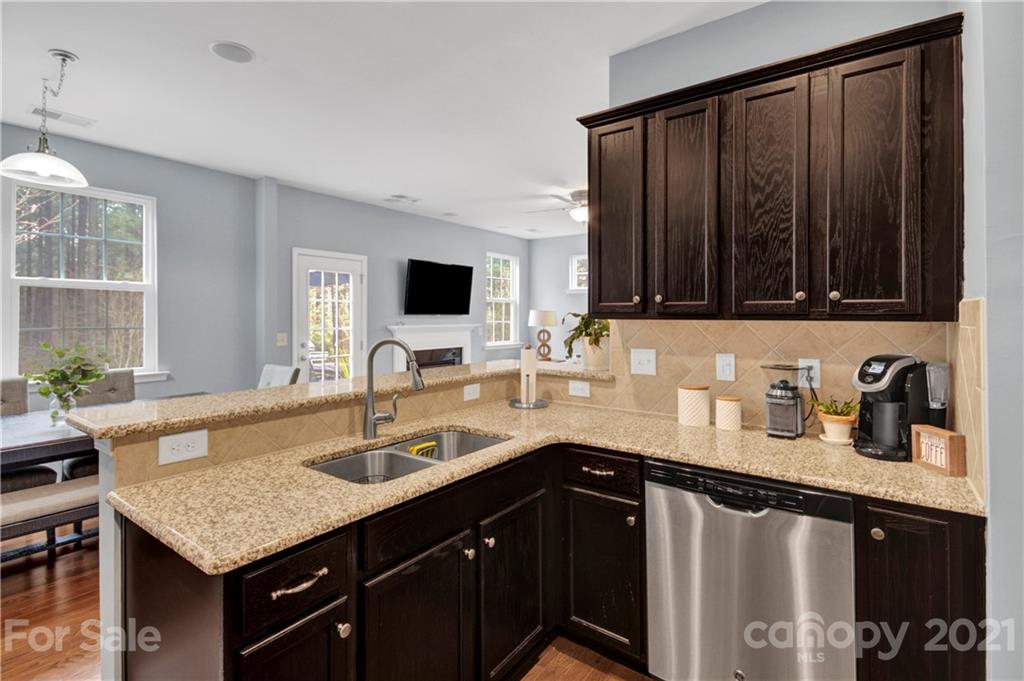 78174 Rillstone Drive Lancaster, SC 29720 - Photo 14 of 33 a kitchen with a sink dishwasher a stove and a microwave with wooden floor