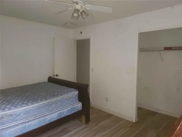 a bedroom with a bed and wooden floor