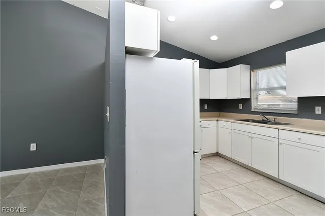 a kitchen with granite countertop white cabinets and a sink
