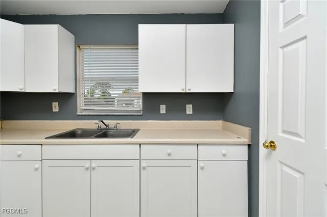 a kitchen with white cabinets sink and white appliances