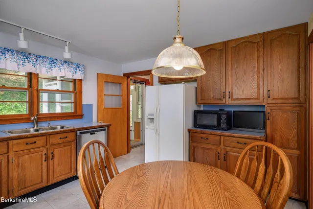 a kitchen with stainless steel appliances a kitchen island hardwood floor sink stove dining table and chairs