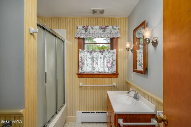 a bathroom with a sink mirror and a bathtub