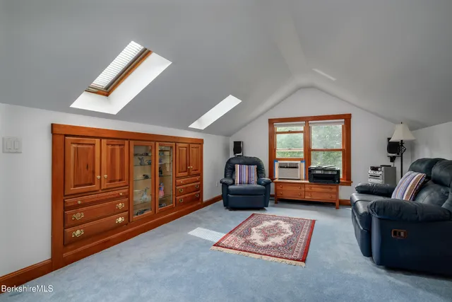 a living room with furniture and a dresser with wooden floor