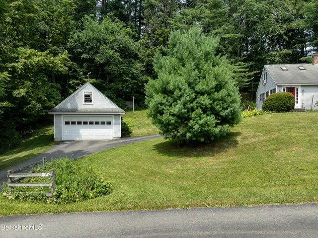 a view of a house with a yard and potted plants