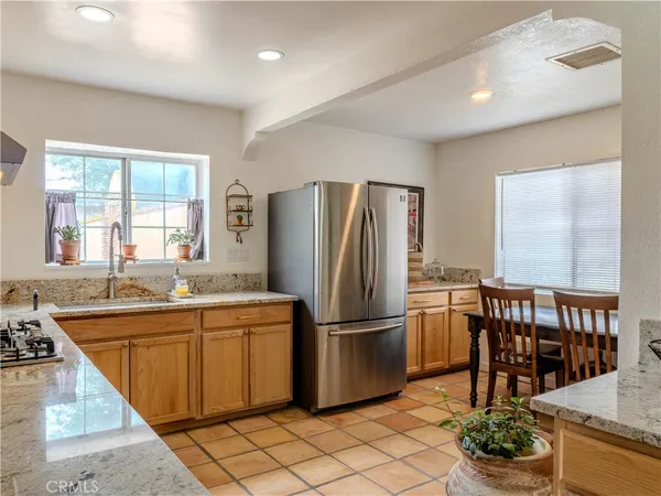 a kitchen with stainless steel appliances granite countertop a refrigerator and a sink