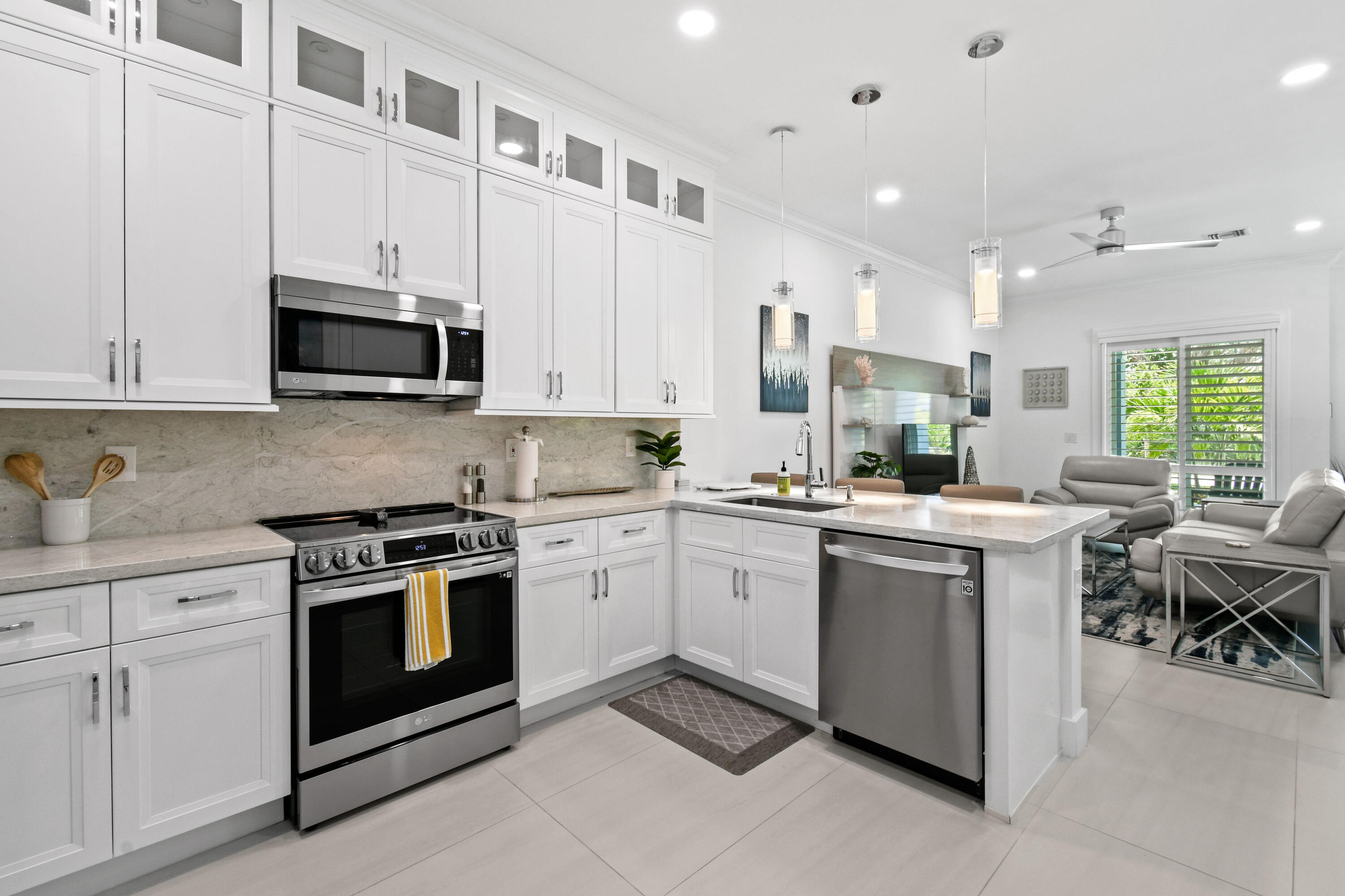 4650 Southeast Manatee Terrace Stuart, FL 34997 - Photo 11 of 95 a kitchen with stainless steel appliances granite countertop a stove a sink and a microwave