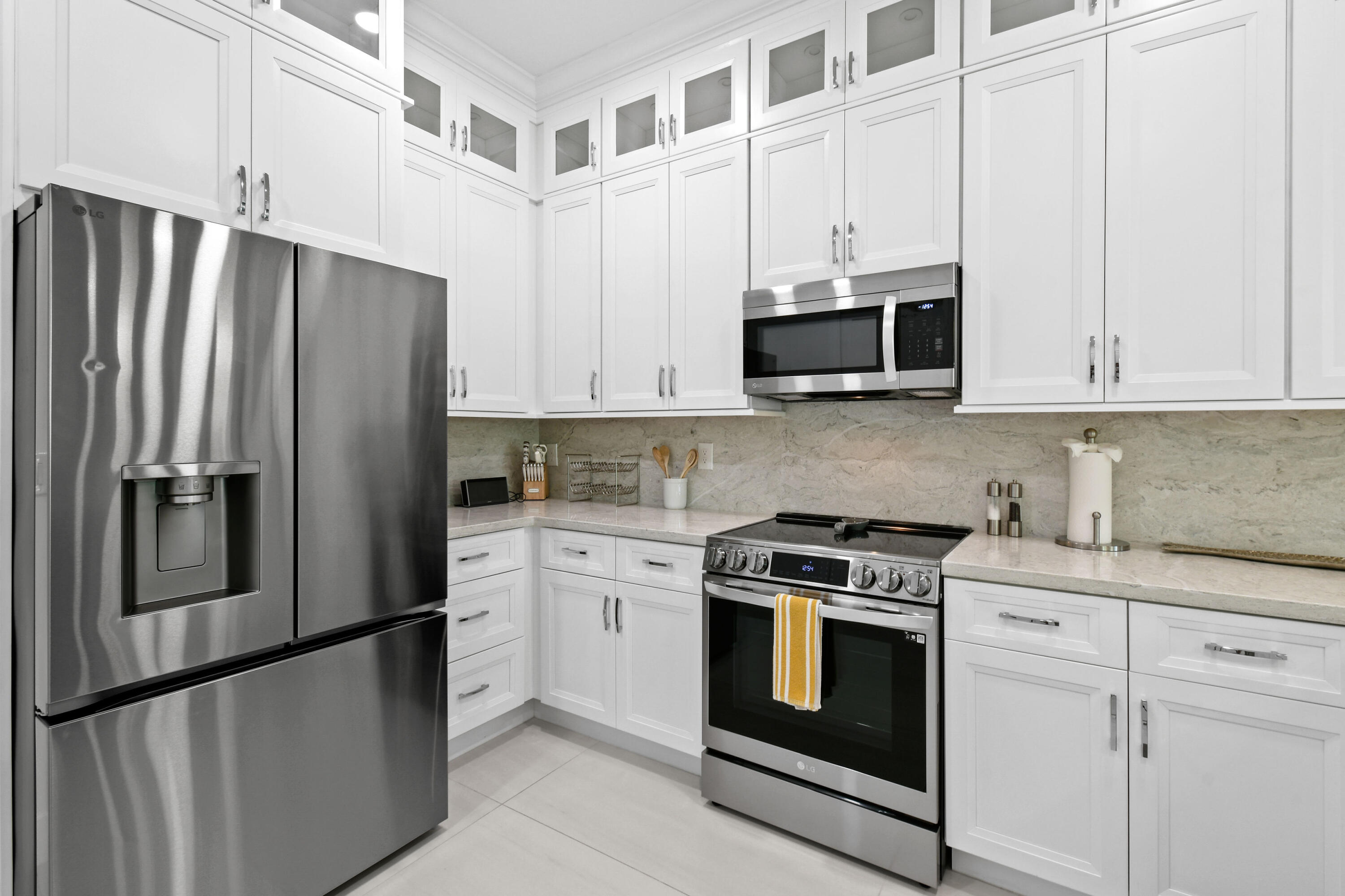 4650 Southeast Manatee Terrace Stuart, FL 34997 - Photo 12 of 95 a kitchen with stainless steel appliances granite countertop white cabinets and a refrigerator