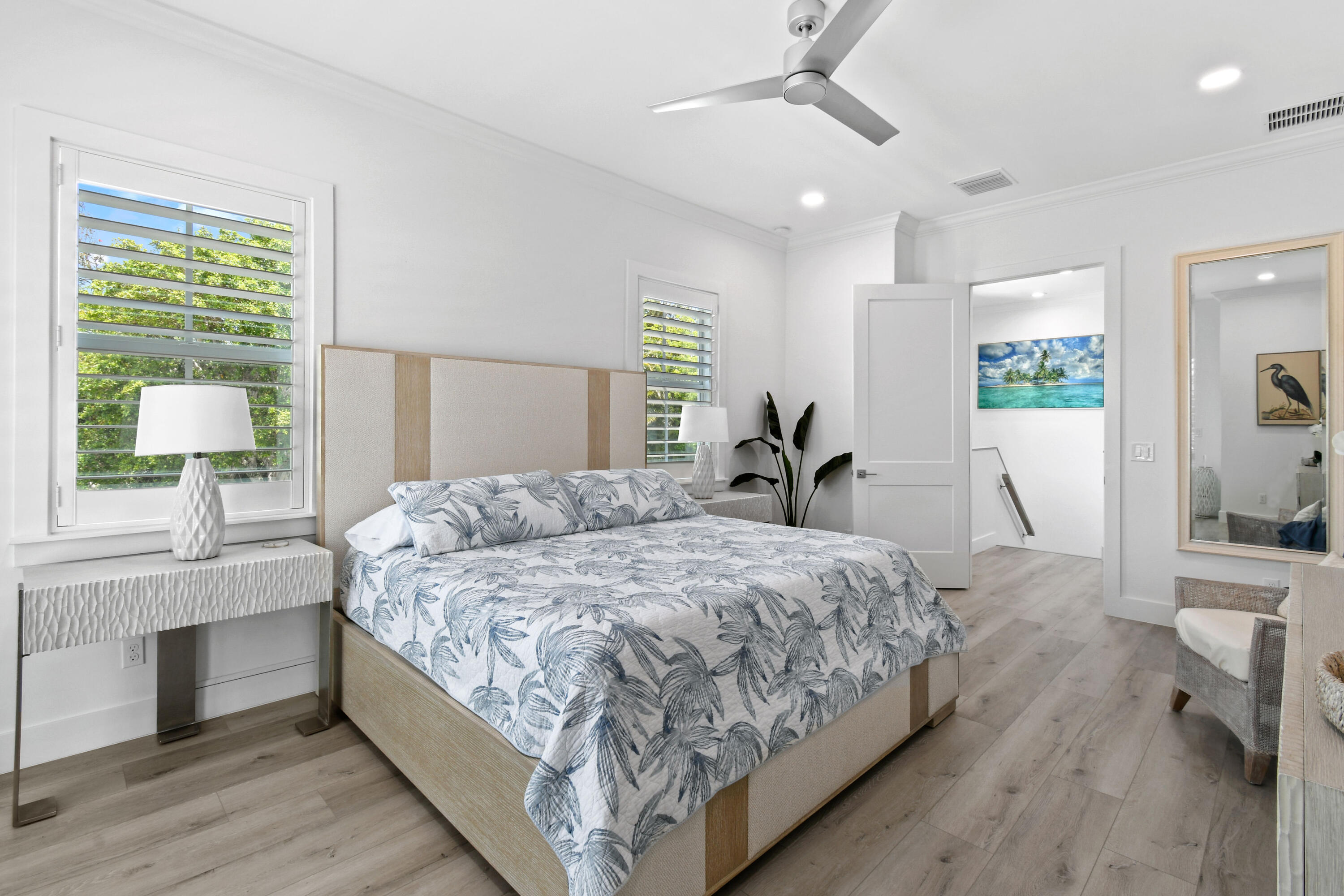 4650 Southeast Manatee Terrace Stuart, FL 34997 - Photo 23 of 95 a bedroom with a large bed and a chandelier