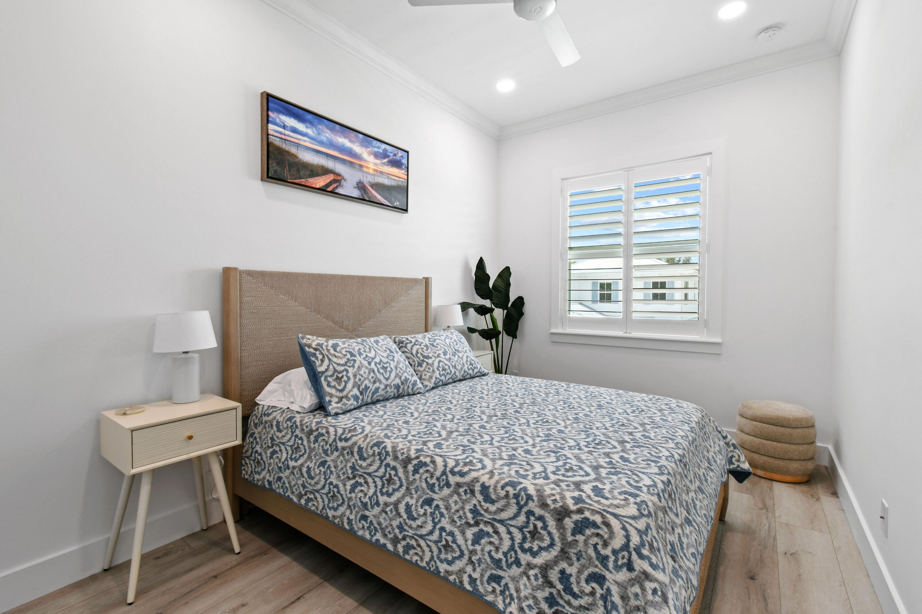 4650 Southeast Manatee Terrace Stuart, FL 34997 - Photo 32 of 95 a bedroom with a bed and a lamp with wooden floor