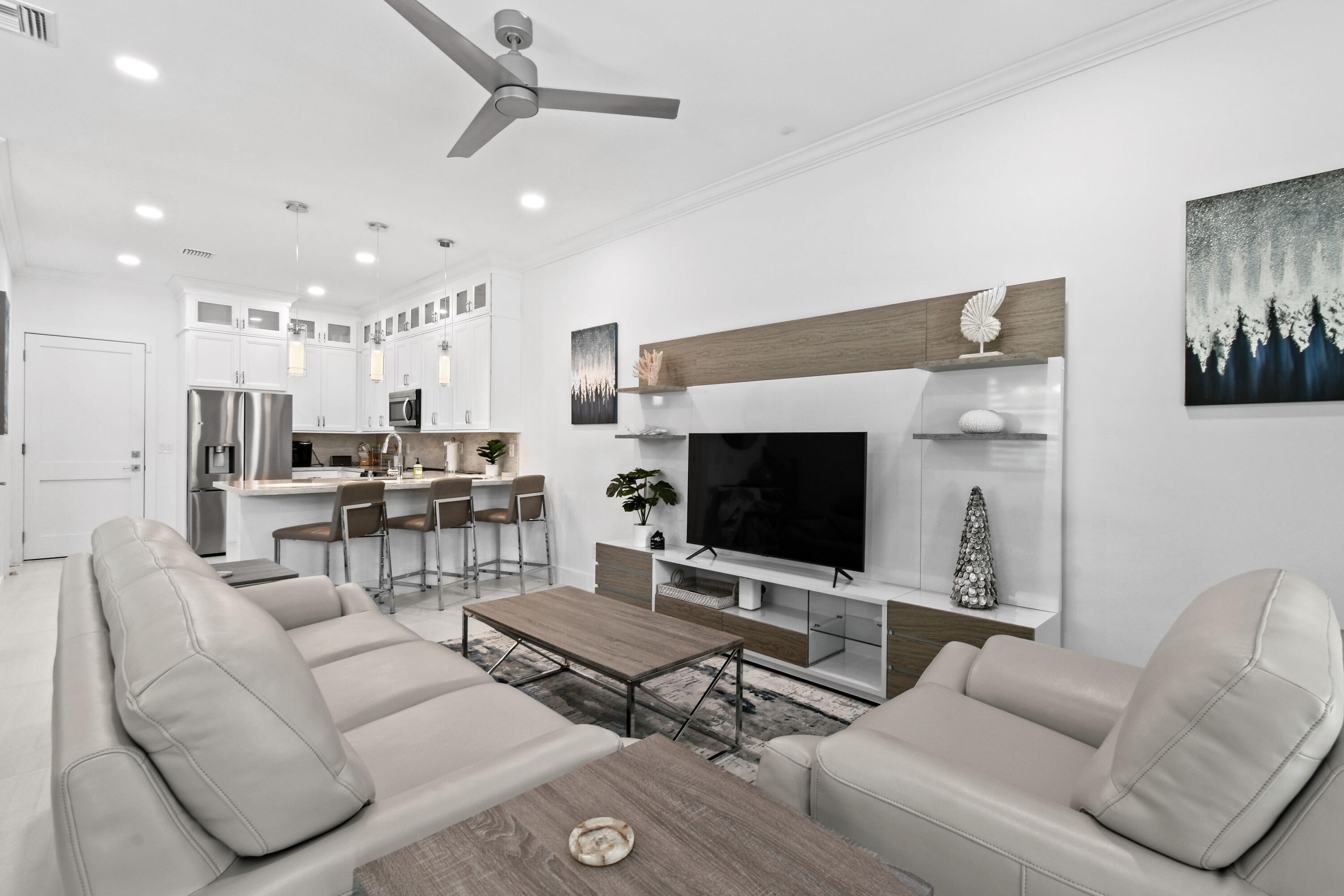 4650 Southeast Manatee Terrace Stuart, FL 34997 - Photo 5 of 95 a living room with furniture a flat screen tv and kitchen view