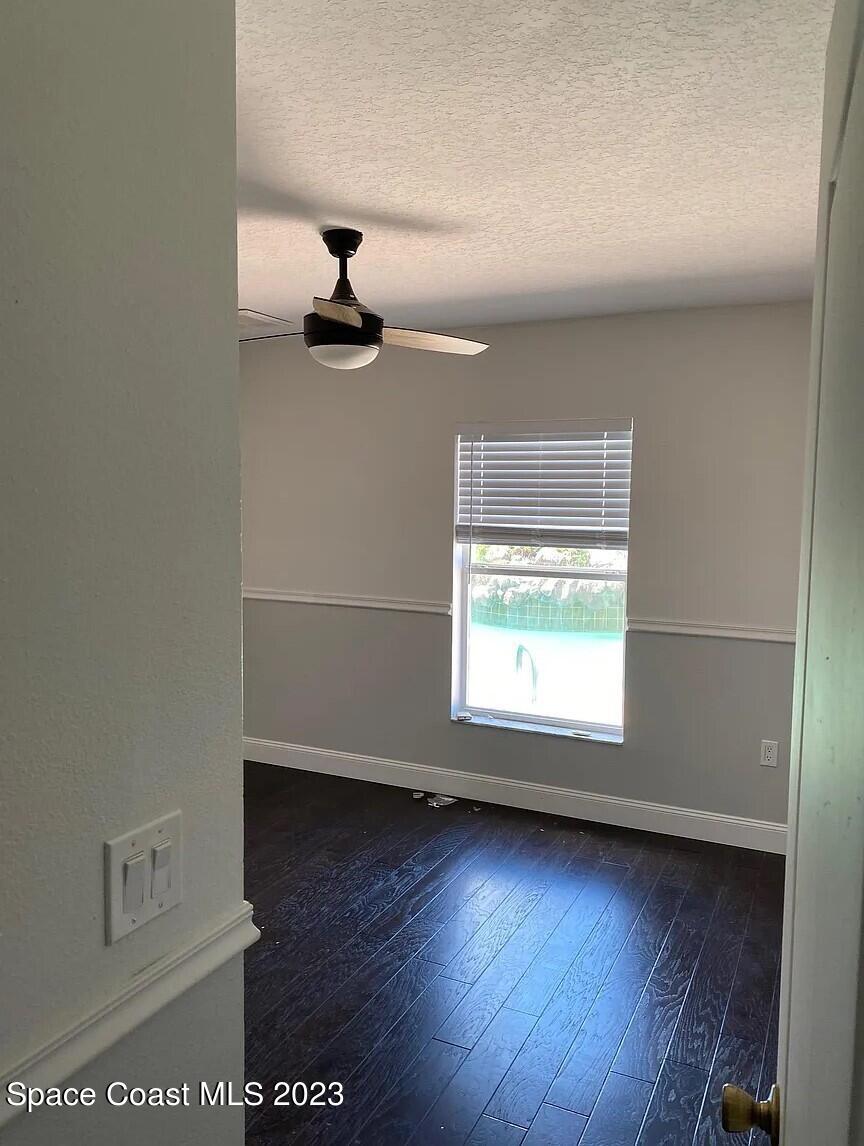 1913 Gloria Circle Palm Bay, FL 32905 - Photo 12 of 18 an empty room with wooden floor and windows