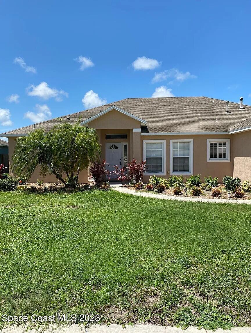1913 Gloria Circle Palm Bay, FL 32905 - Photo 2 of 18 a front view of house with yard and outdoor seating