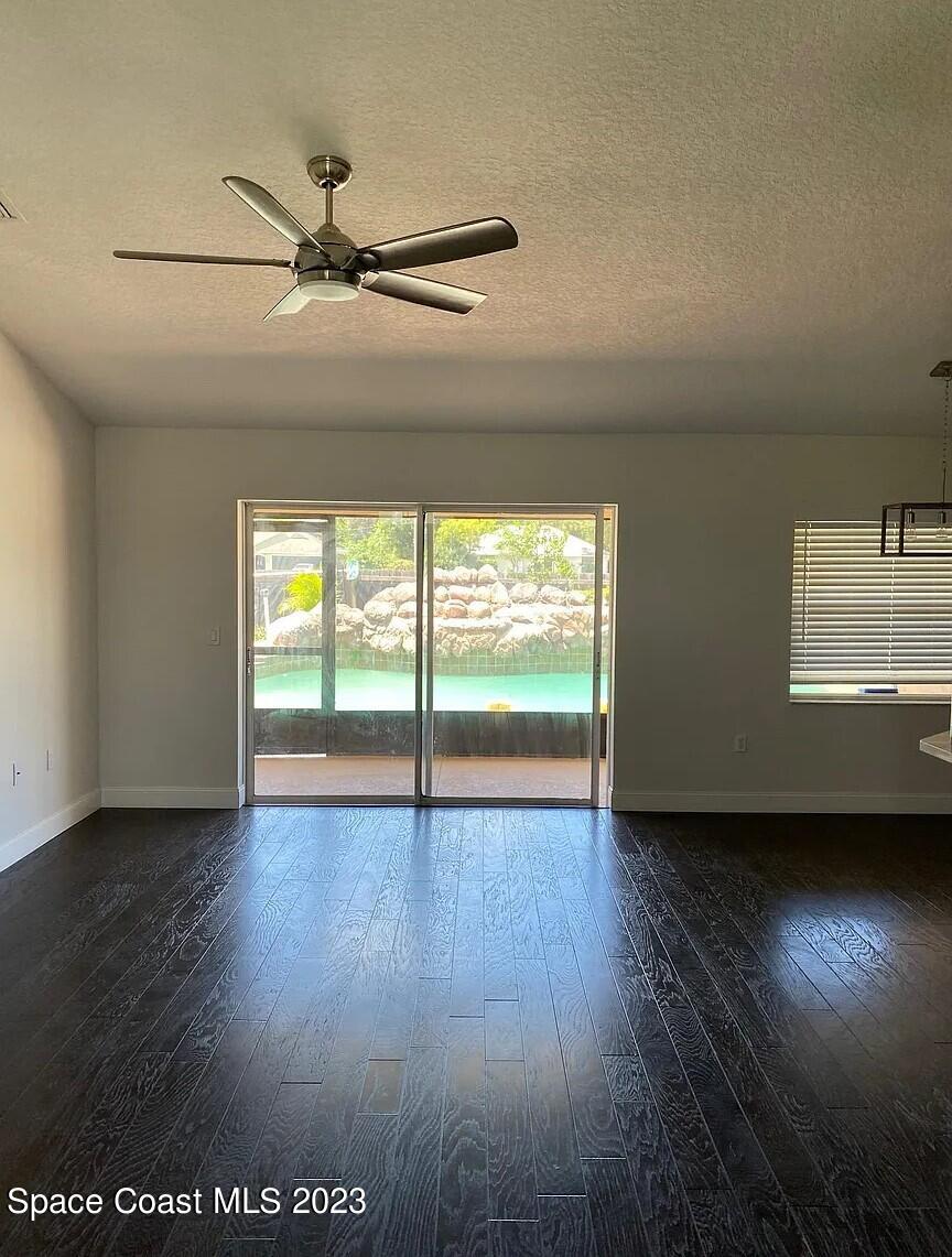 1913 Gloria Circle Palm Bay, FL 32905 - Photo 4 of 18 an empty room with wooden floor fan and windows