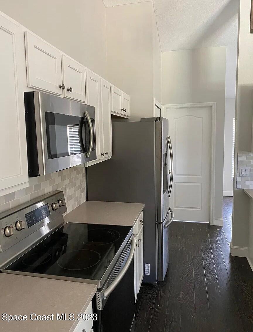 1913 Gloria Circle Palm Bay, FL 32905 - Photo 6 of 18 a kitchen with a refrigerator stove and microwave